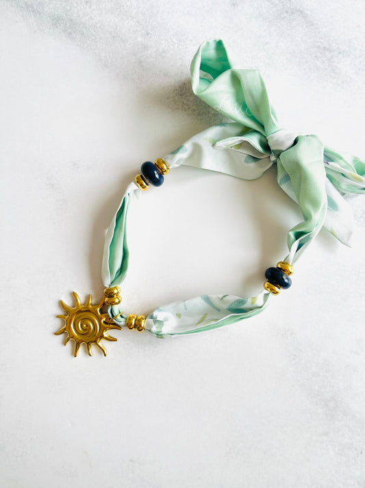 Collar tela verde con dije de sol de Acero Inoxidable con Baño 18K